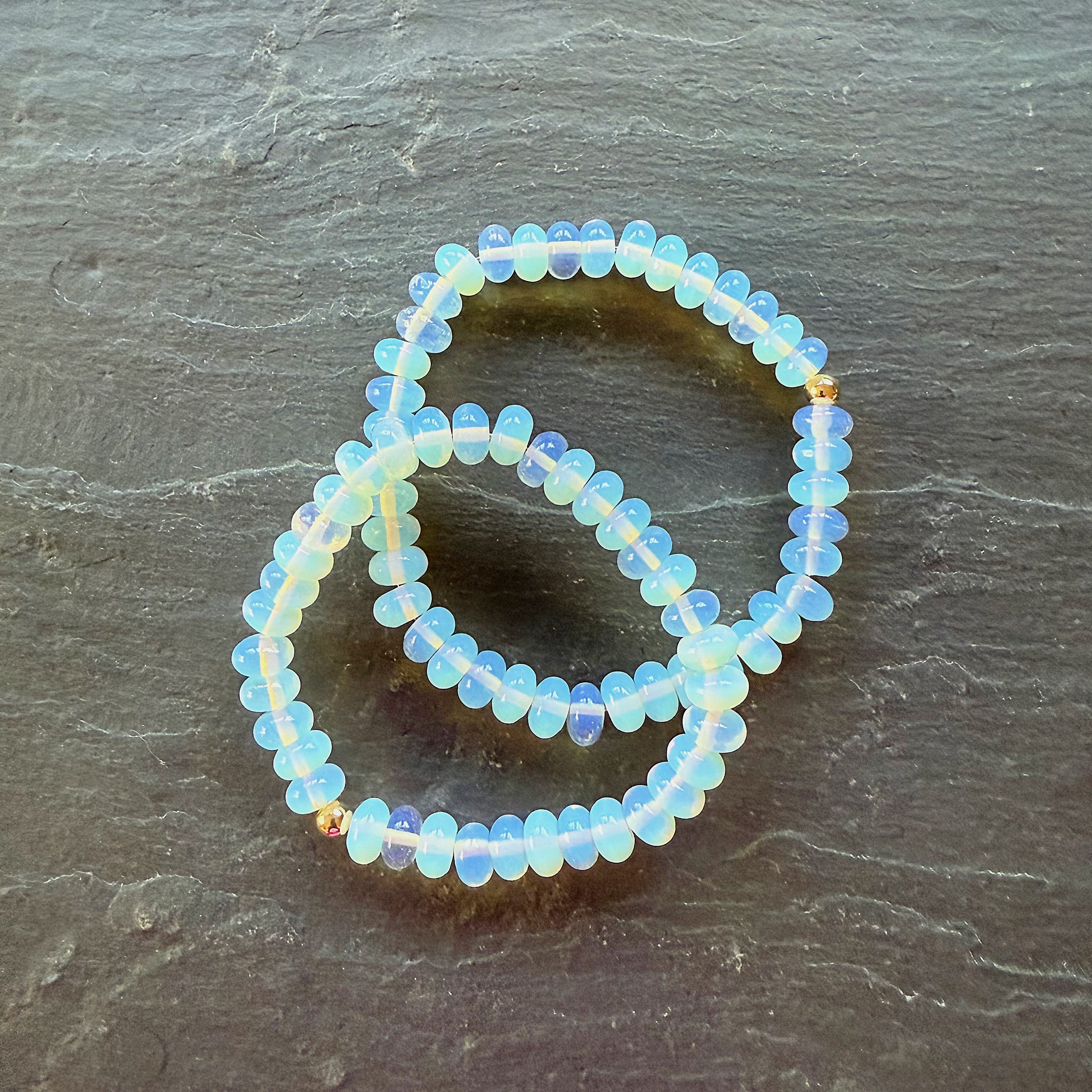 Opalite beaded bracelet on a dark stone surface