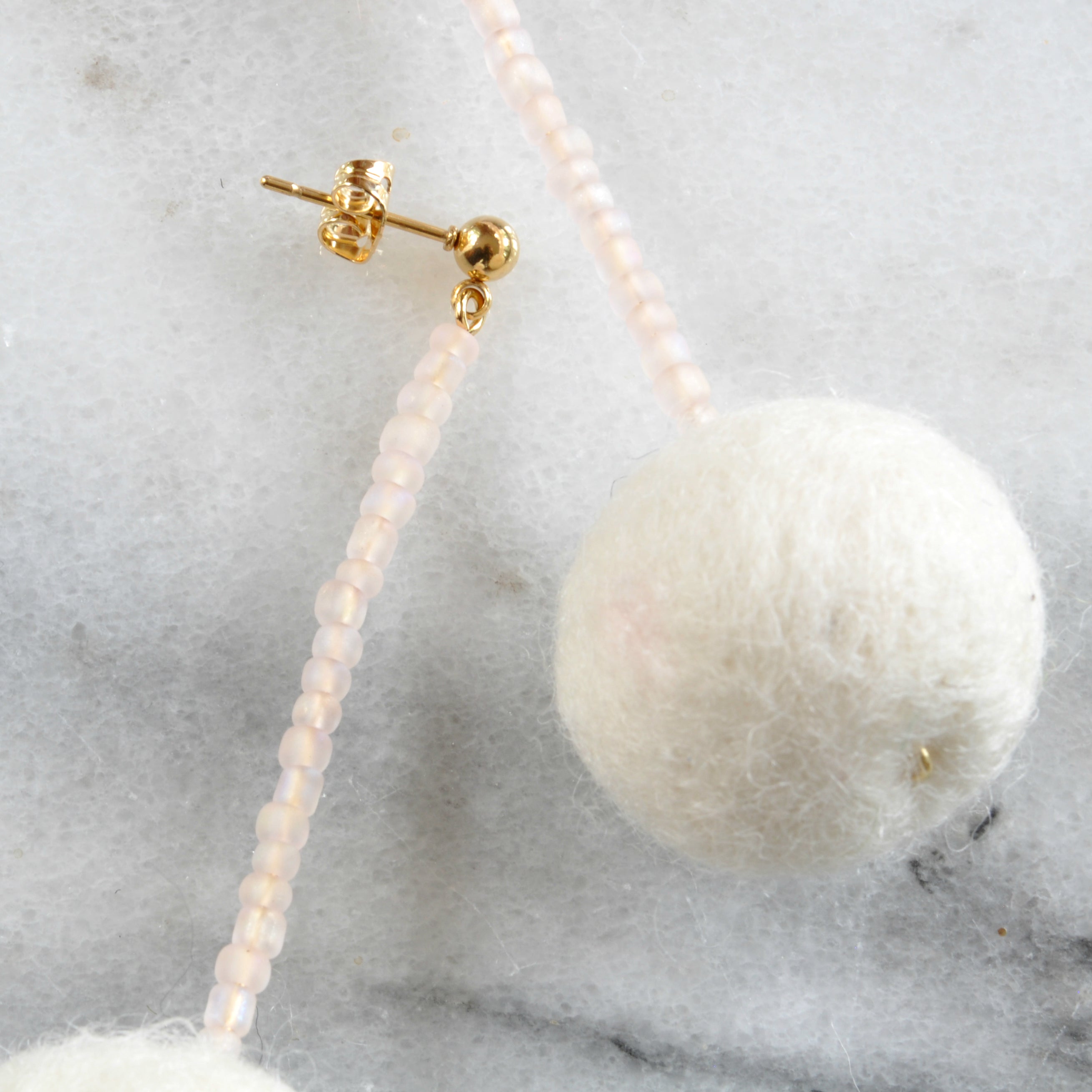 Libby & Smee pom pom earrings in Cream with Blush color combination, close up