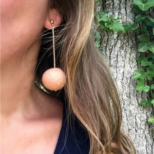 Libby & Smee pom pom earrings in Blush color combination, close up on model 