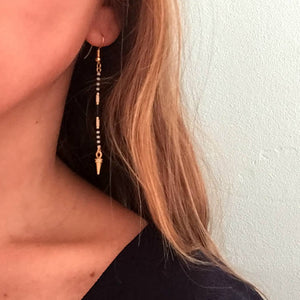 Long beaded earrings from Libby & Smee with a gold earwire and beaded pattern in Monochrome pattern with black, cream and gold beads on model