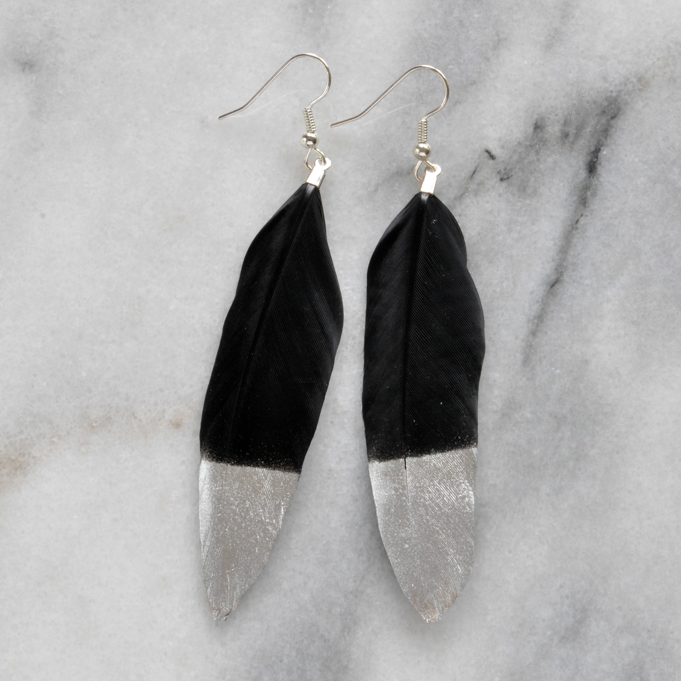 Libby & Smee Gold and Silver Feather Earrings in black with silver, still life 
