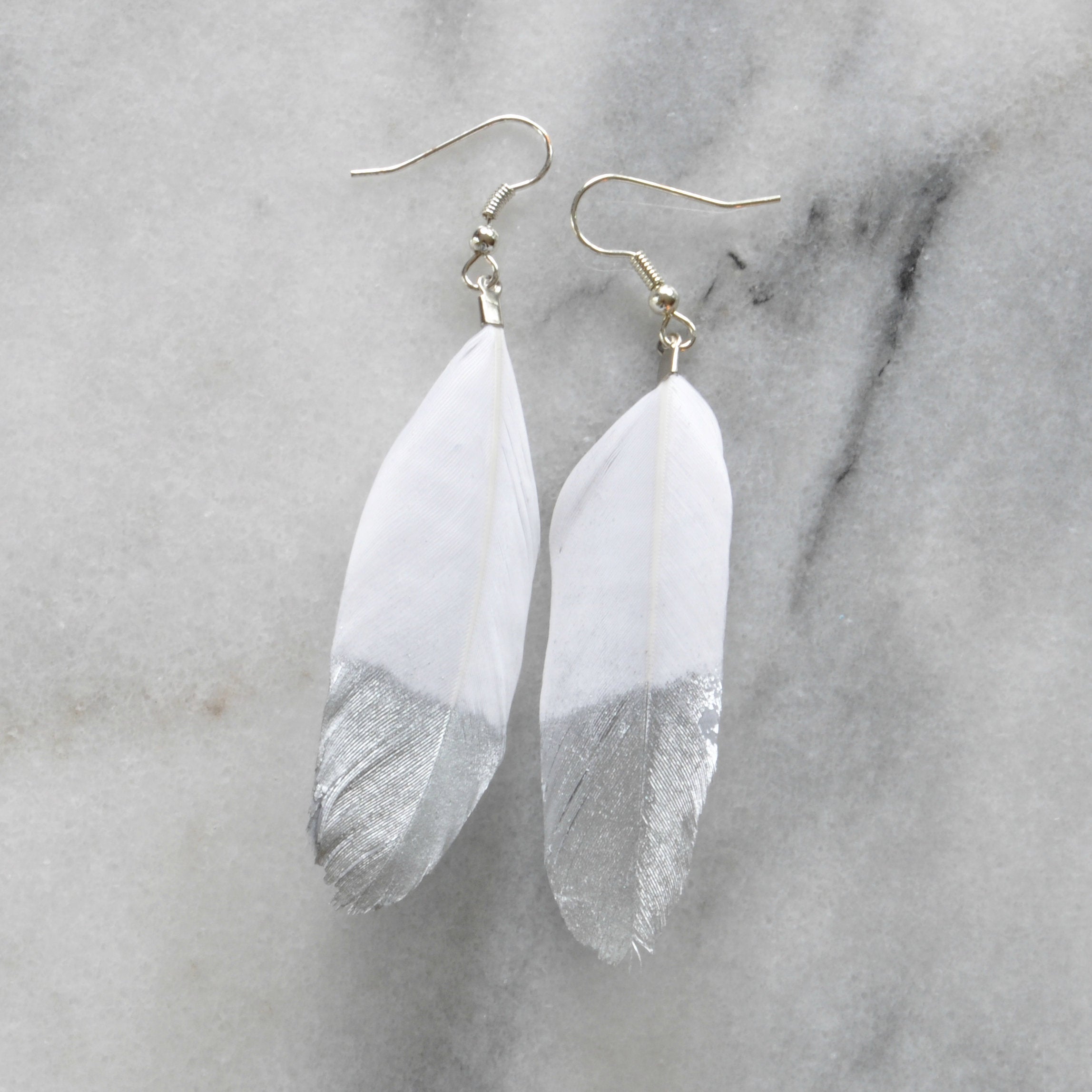 Libby & Smee Gold and Silver Feather Earrings in white with silver,  still life 