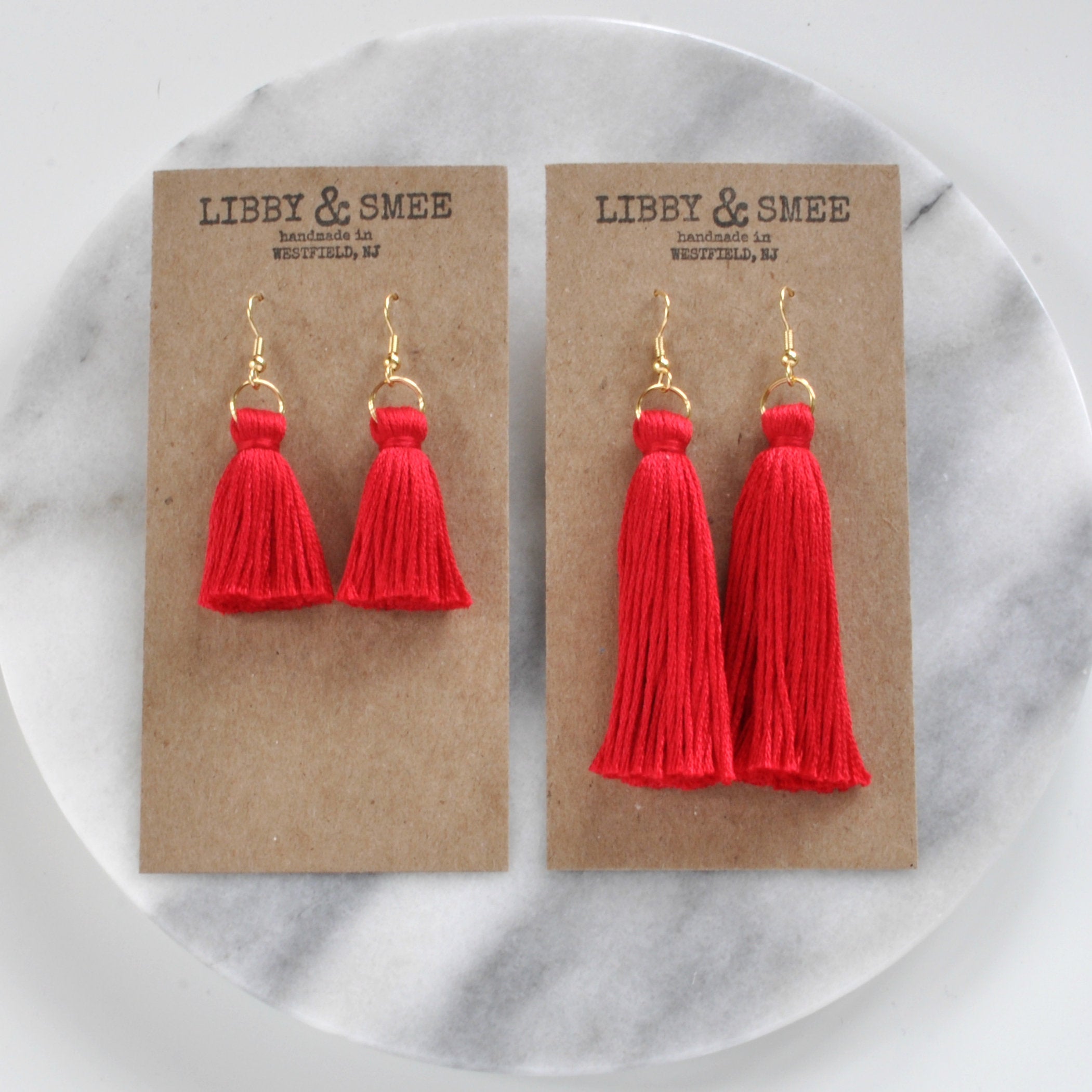 Libby & Smee red tassel earrings on gold earwires in mini or long on logo kraft earring cards, overhead angle