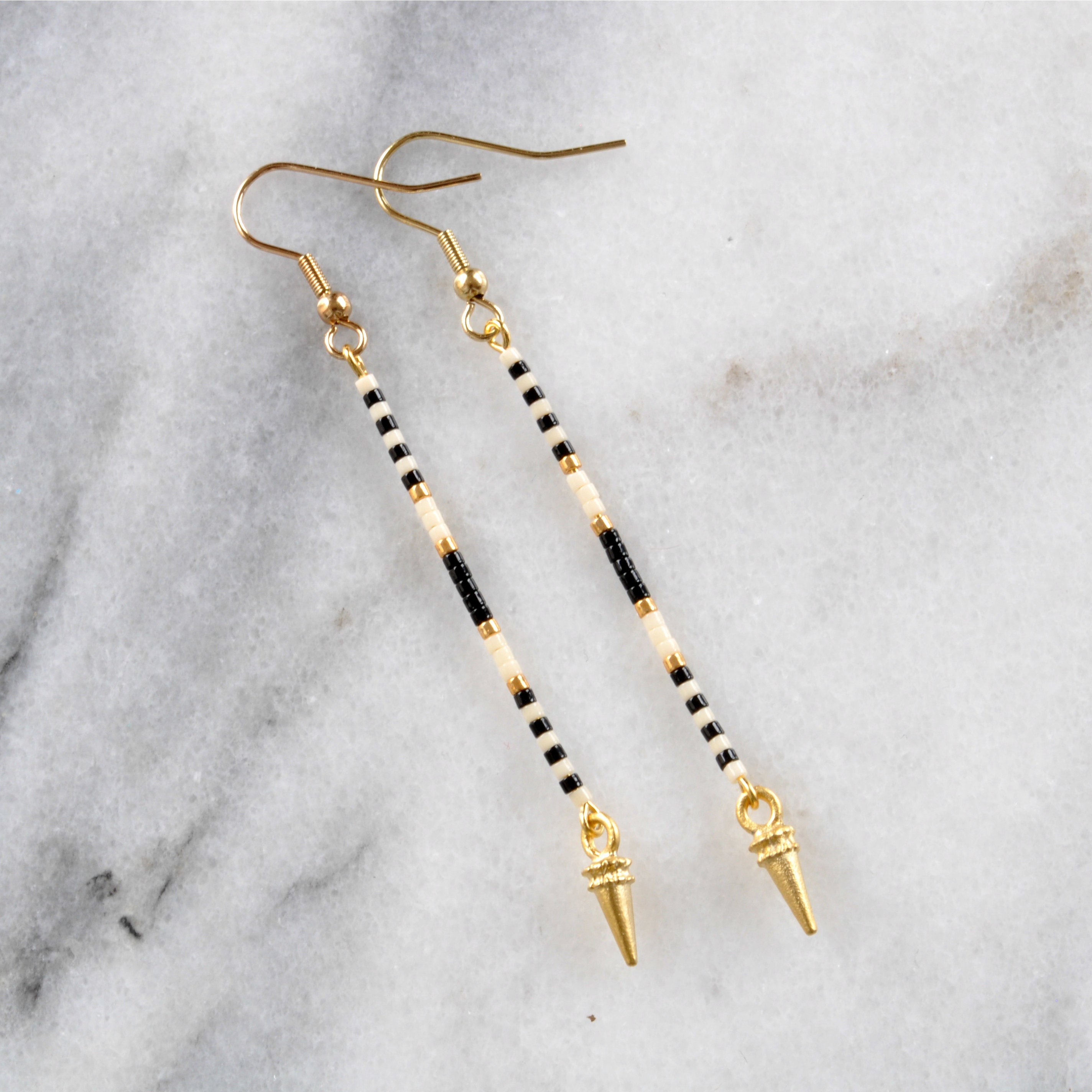 Long beaded earrings from Libby & Smee with a gold earwire and beaded pattern in Monochrome pattern with black, cream and gold beads