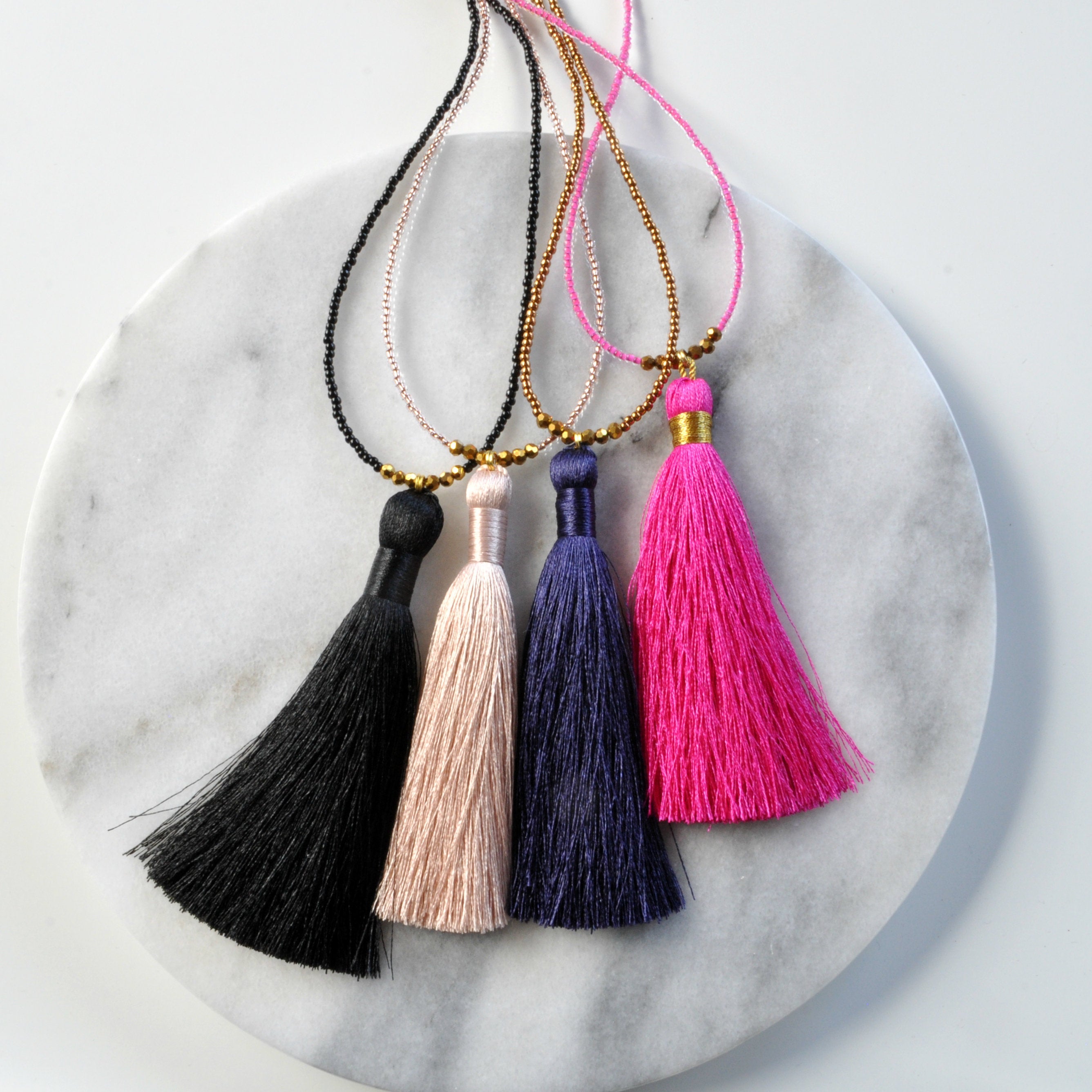 Libby & Smee Beaded Tassel Necklace in Black, Champagne, Navy and Fuchsia, still life