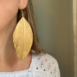 Libby & Smee 5 inch long gold feather earrings, on model