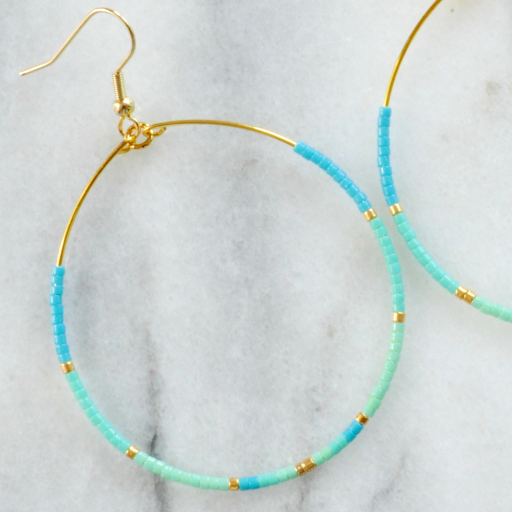 Libby & Smee Big Beaded Hoops in "Aruba" style with gold-plated ear wire and small seed beads in turquoise, aqua, mint and gold in size "big" teardrop shape - close up 
