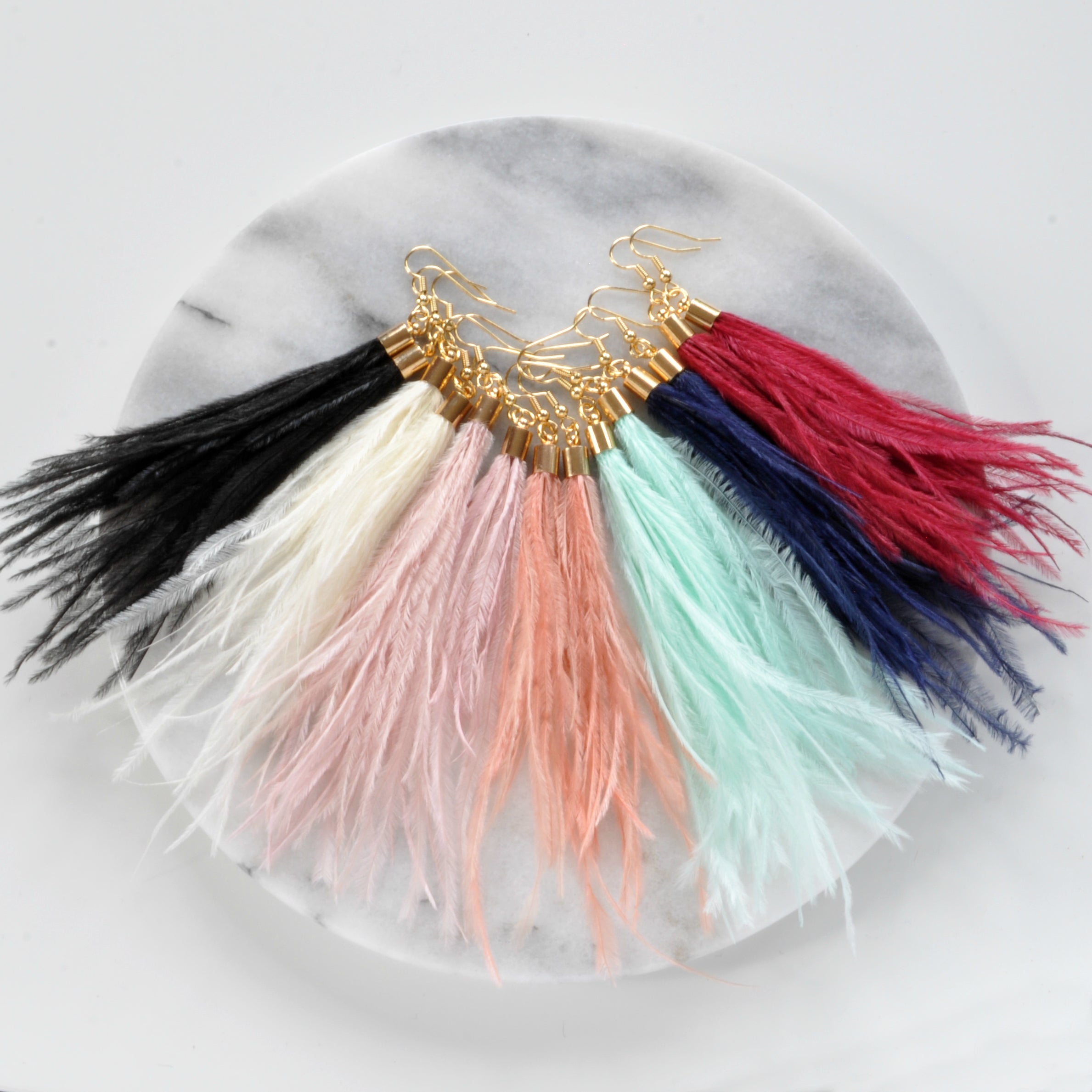 Libby & Smee dusty pale pink feather earrings with ostrich feathers and gold caps, still life with other Libby & Smee ostrich feather earrings